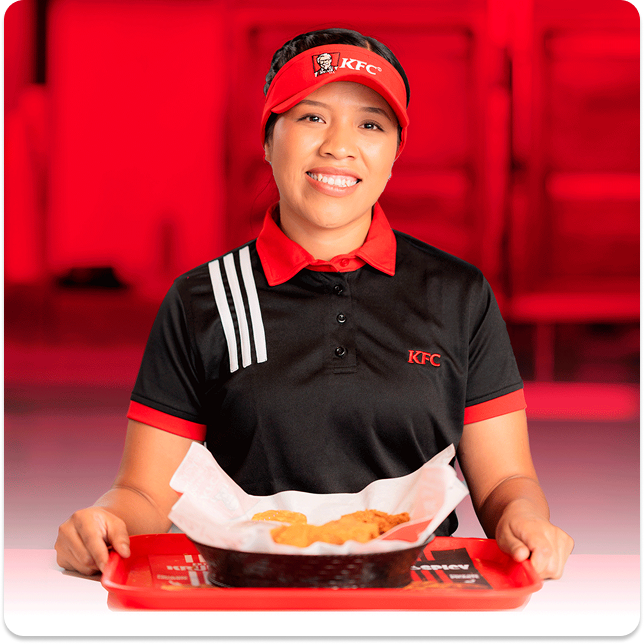 Empleado con delantal con una bandeja de pollo